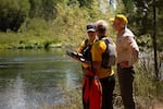 The members of the search and rescue team discuss their drone flight schedule in preparation for a pass Dillon Falls along the Deschute River in Deschut County, Ore.